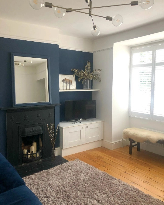 Matte Black Fireplace Against A Navy Blue Chimney Breast